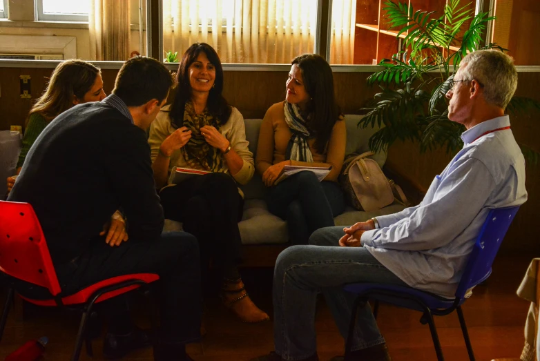 several people talking together while sitting in a group