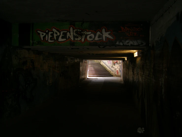an empty tunnel with graffiti all over it
