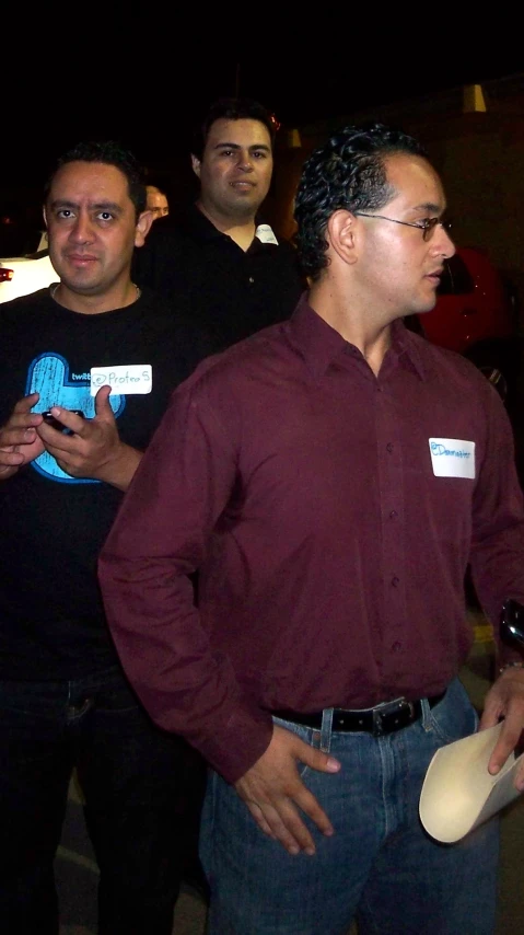 a man stands next to two men holding a disc