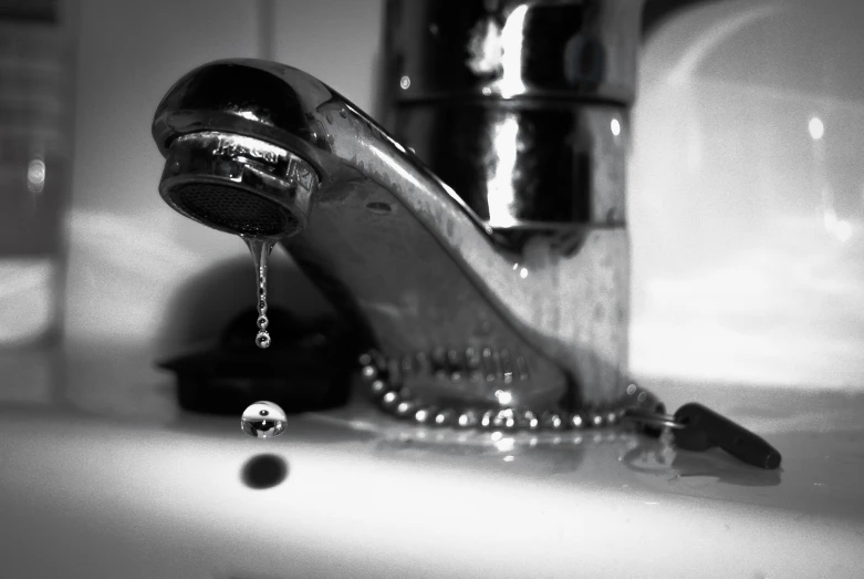 a sink faucet with a chrome plated finish, running water