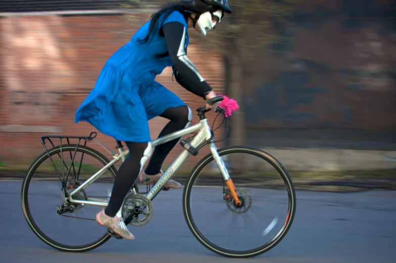 woman riding a bicycle with colorful flowers on the wheel