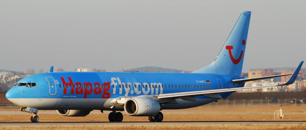 a blue jet airplane with foreign writing on the side