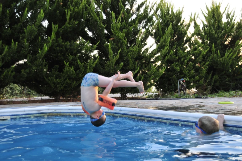 man diving into swimming pool to catch incoming air