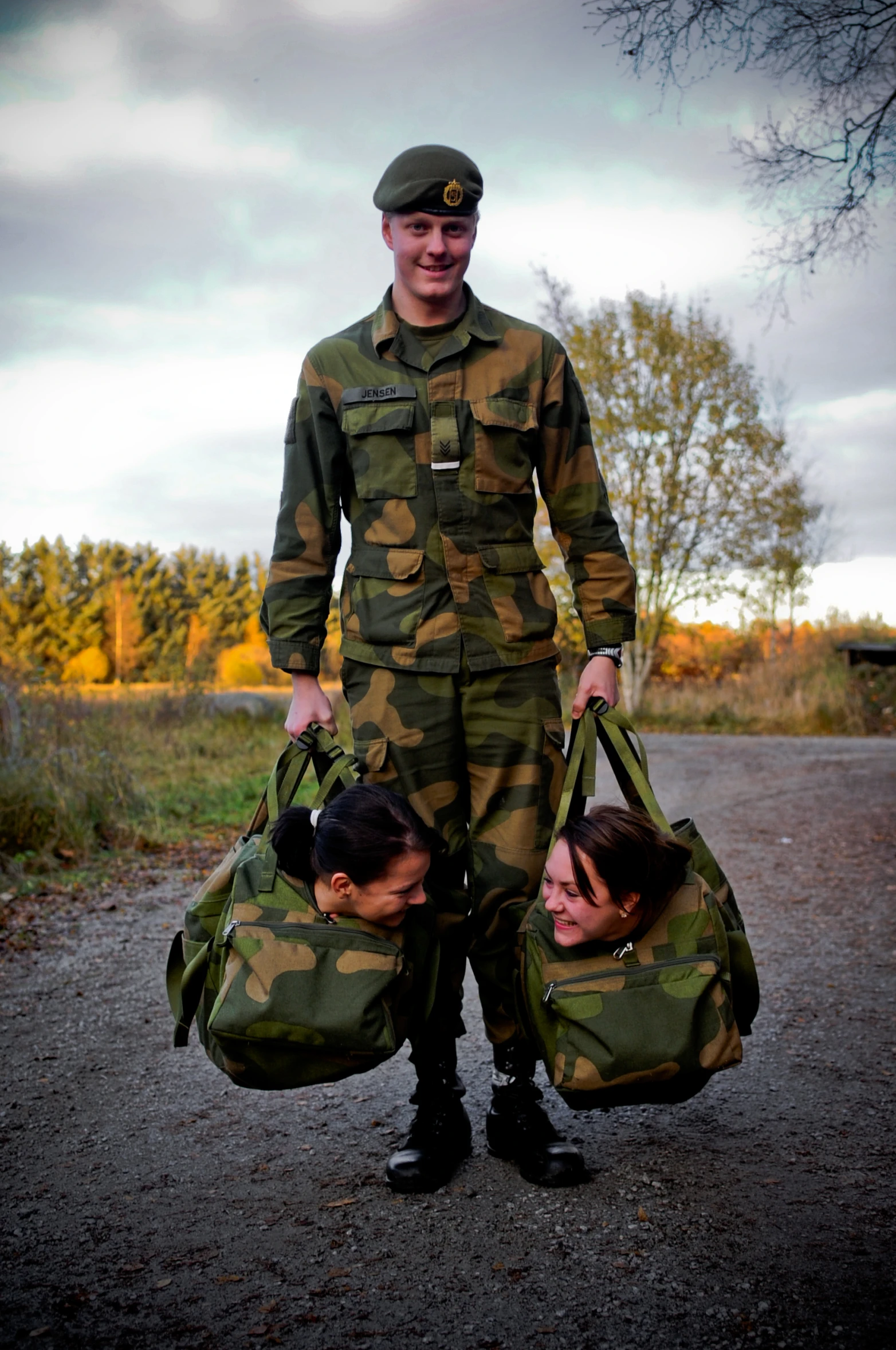 a man in military fatigues carrying luggage while holding two other persons