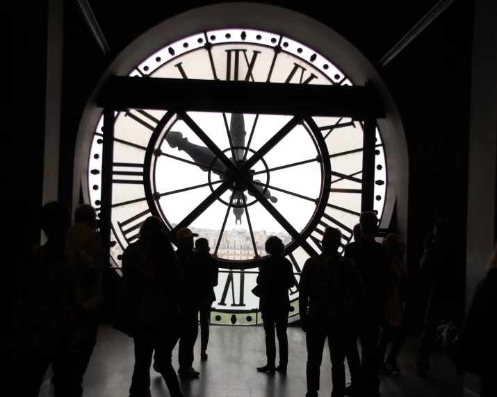 a large clock with people standing inside of it