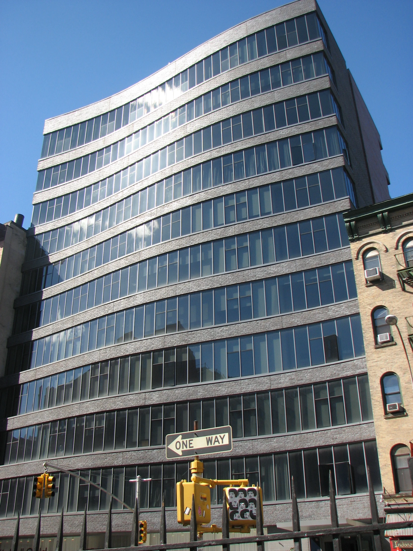 building with glass fronted corner near street intersection