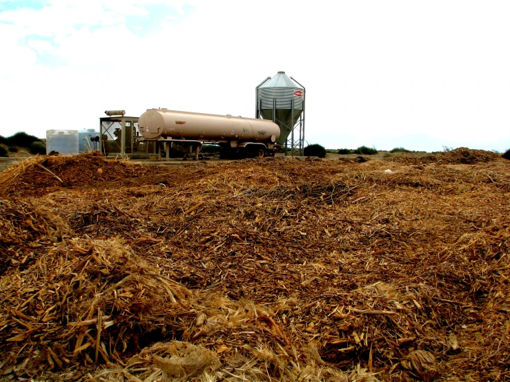 a dry grassy field with a gas tank on top of it