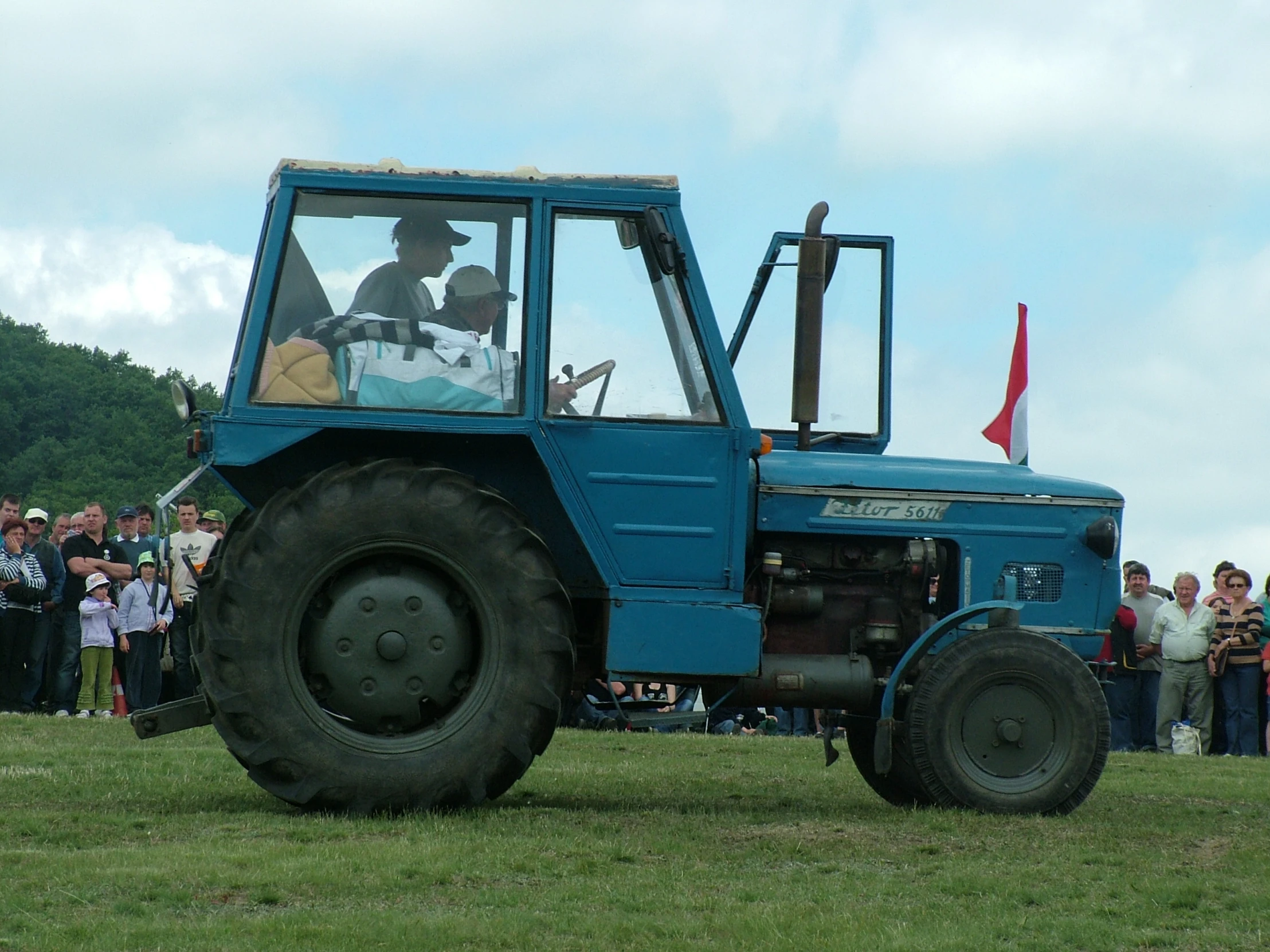 blue truck sitting on top of a lush green field