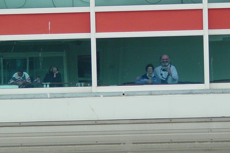 people looking through the windows of a red and white building