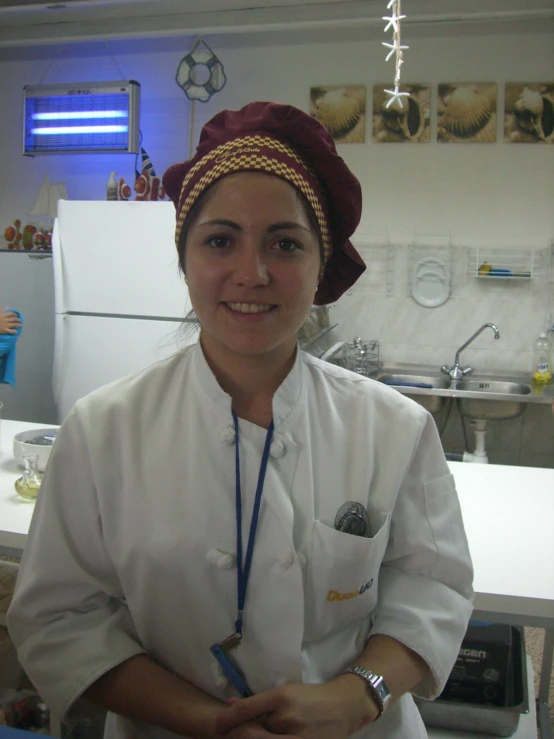 a woman wearing a chef coat and smiling