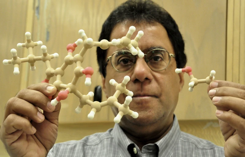 a man in glasses shows some white and red structures