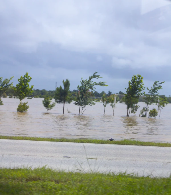 water rises up over the roadway from flood waters