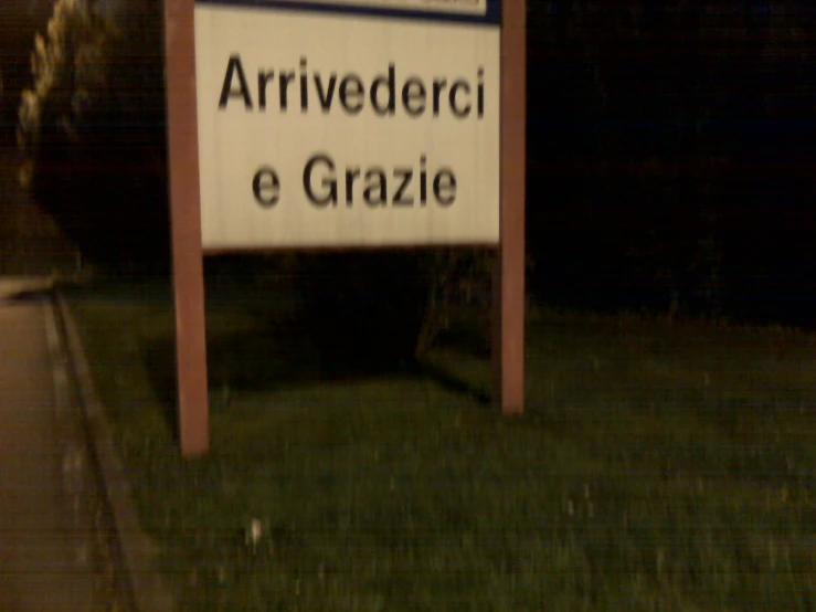 a sign in a garden that says arrviederci e grazie