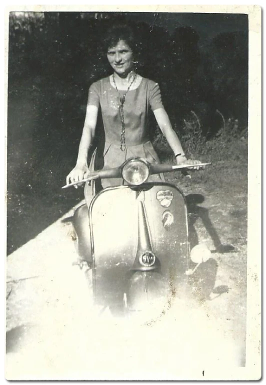 a woman sitting on a small motorcycle with her hair in pigtails
