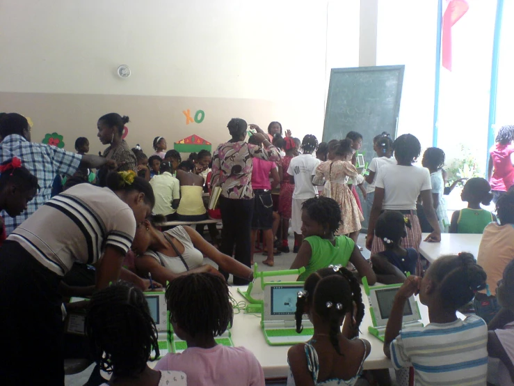 a group of young children standing around each other with electronic devices