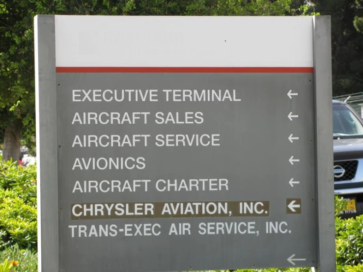 a sign shows direction to private airport, including a truck