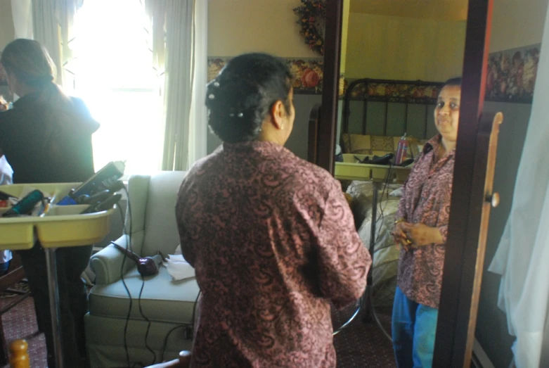 a man looking in a mirror while standing next to a bathroom sink