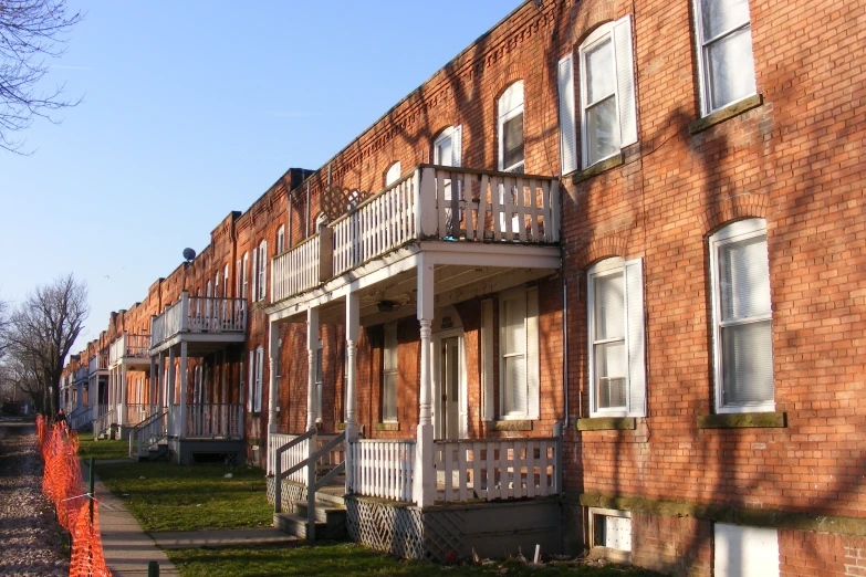 a row of brown brick townhouses next to trees