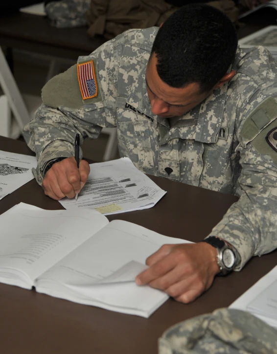 a soldier is doing paperwork and writing soing on a paper