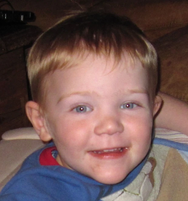 a small boy is sitting on a sofa