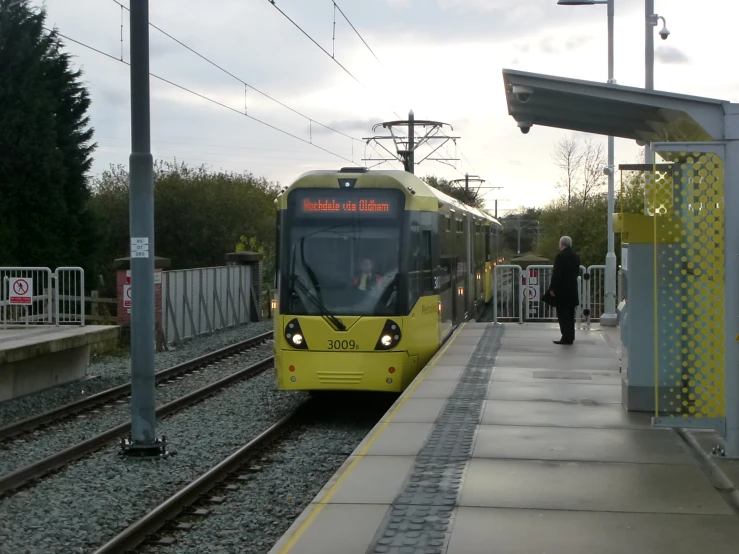 train on tracks next to platform at outdoor station