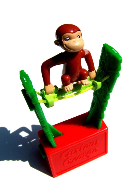 a toy monkey riding on the back of a snowboard