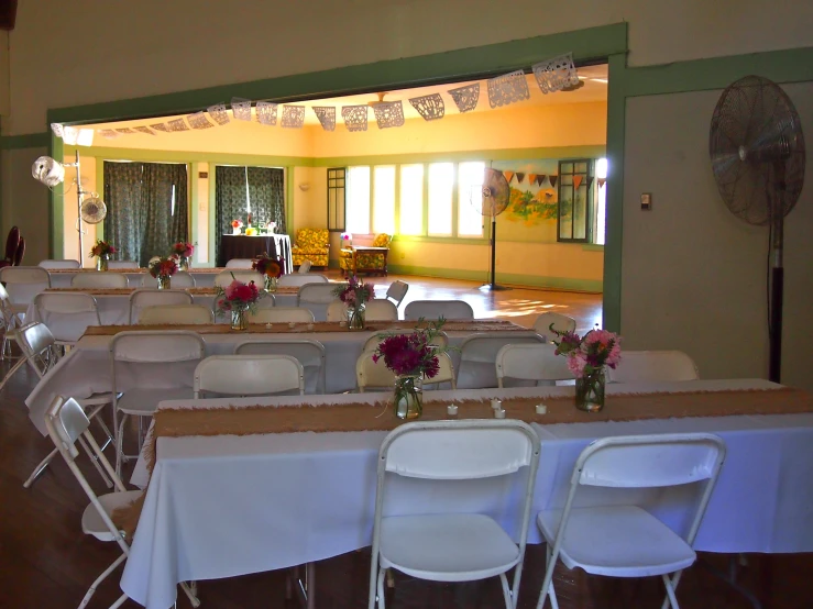 a long room is set with a lot of tables and chairs