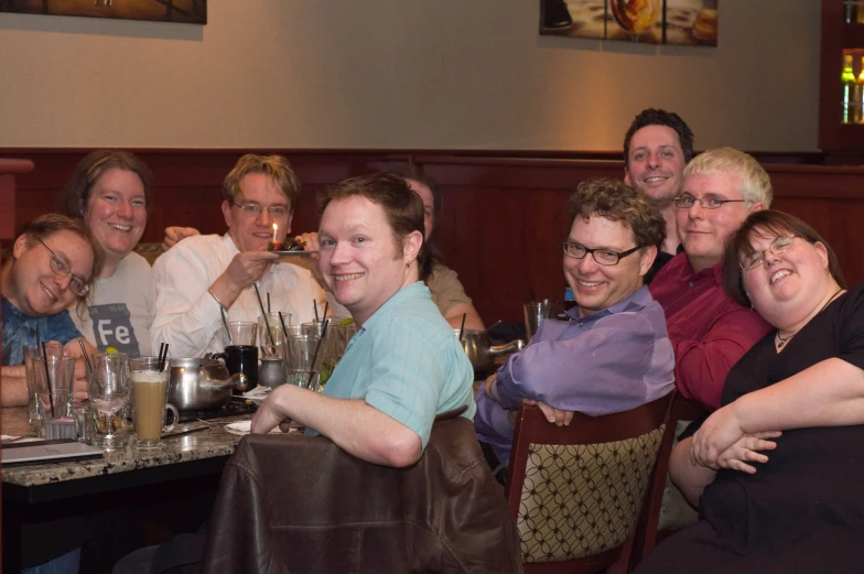 people sitting around a bar posing for the camera