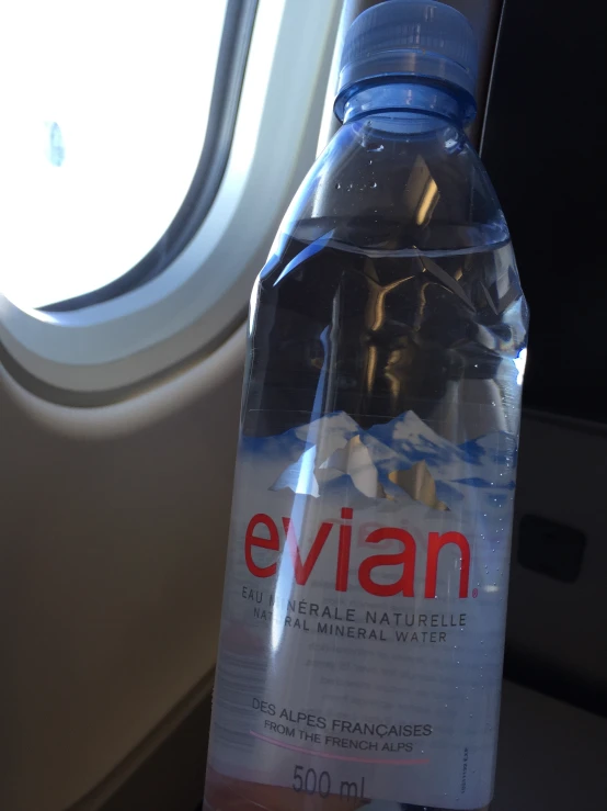 a water bottle sits on the seat of a airplane