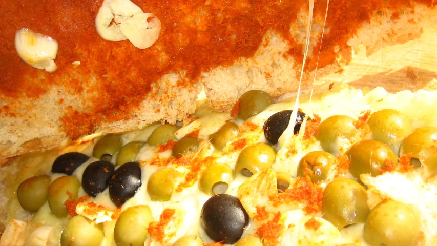 cheese and olives are topped with melted broccoli