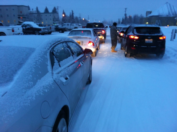 a group of cars driving through snow covered streets