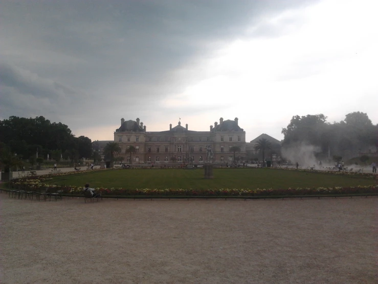 a castle sits near a field surrounded by trees