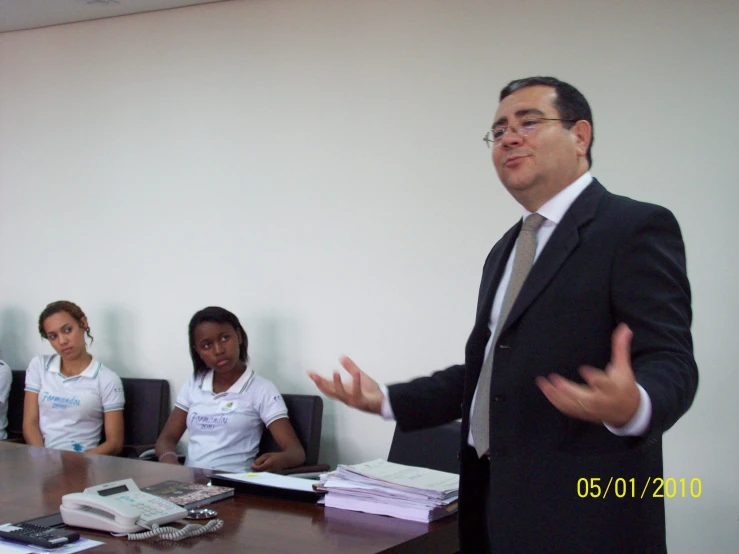 a man in a suit talking to a group of people