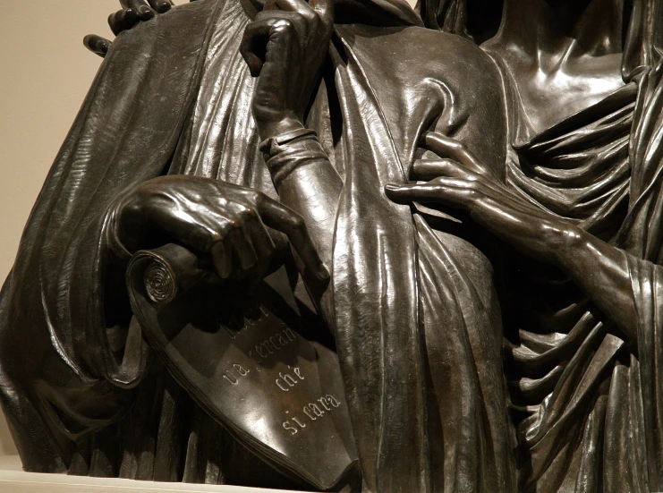 a close up of a statue with a person holding a book