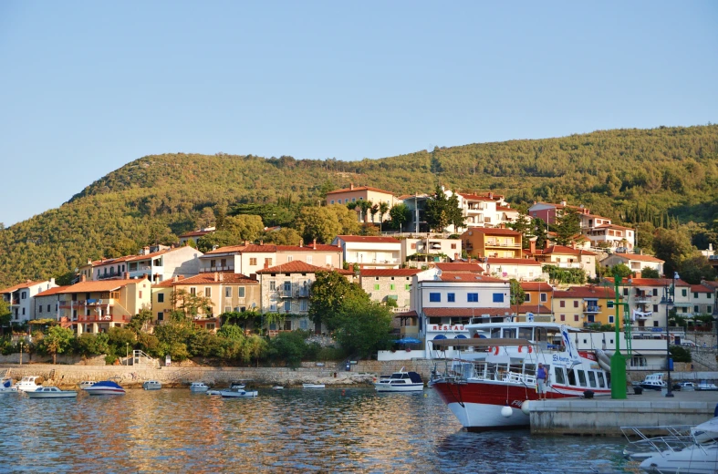 small boats parked in front of houses on top of the hill