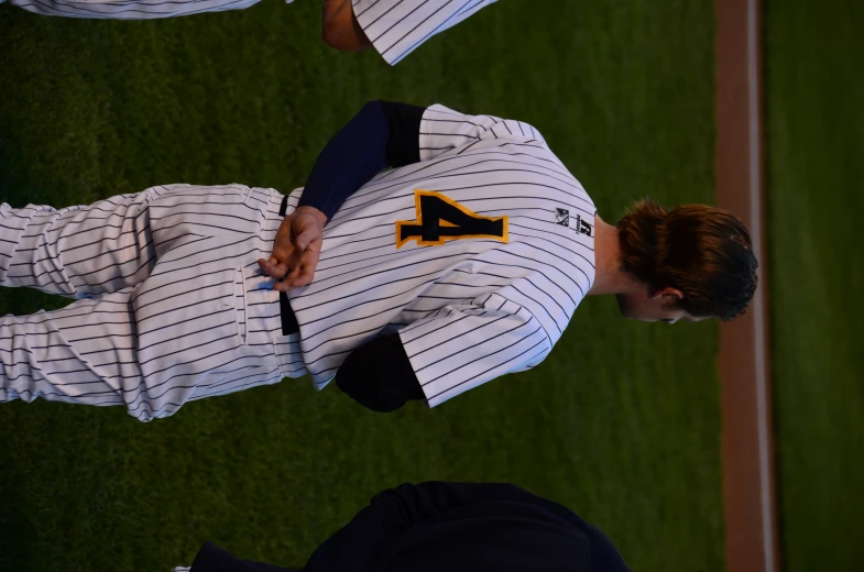 two baseball players stand facing each other in their uniforms