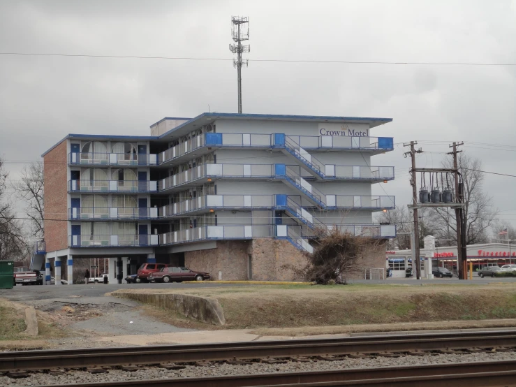 an apartment building sitting on the side of a train track