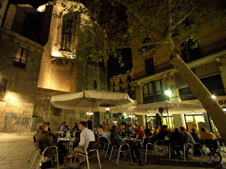 a very crowded dining area with umbrellas for shade