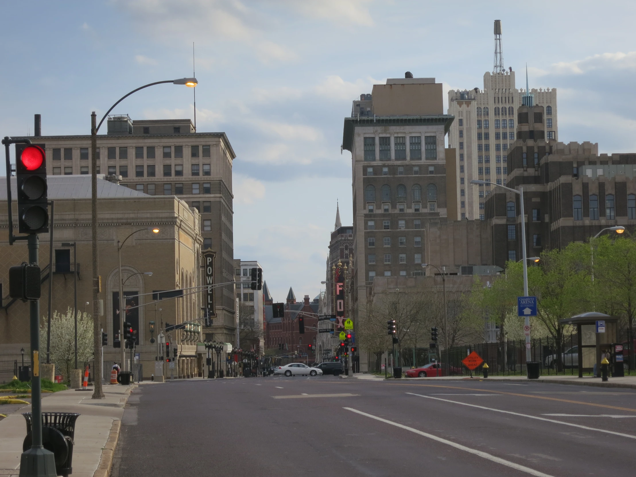 red traffic signal on an empty street with high rise buildings