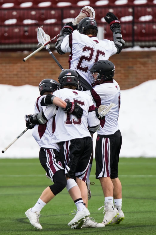 the young men are playing a game of lacrosse