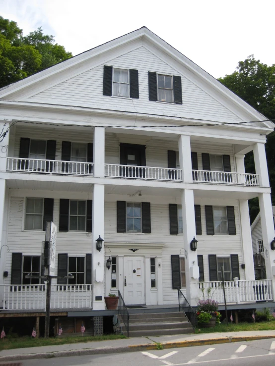 an old style white house in the middle of some trees