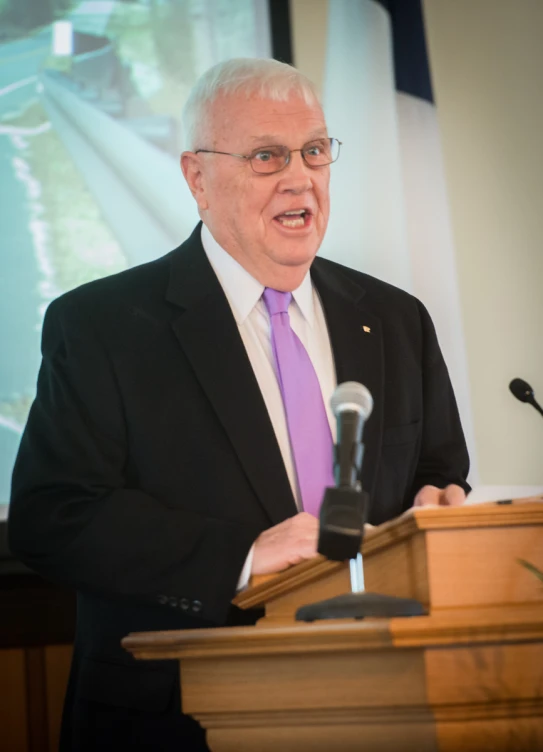 a man giving a presentation from behind a podium