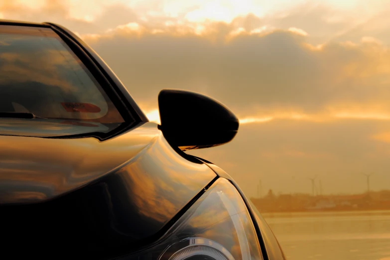 a car door window is opened with the sunset in the background