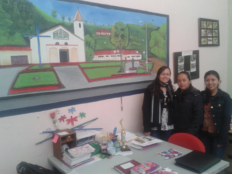 three girls posing for a po in front of art work