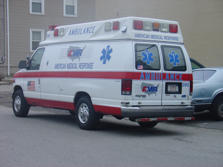 an ambulance parked on the side of the road near a building