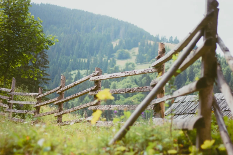 a wooden fence in the middle of a grass field