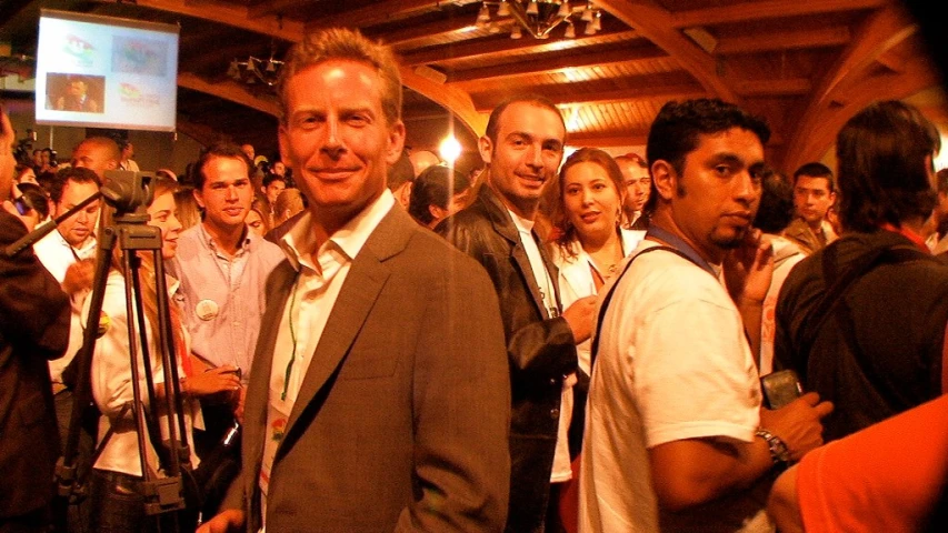 man in suit standing with camera taking po of people