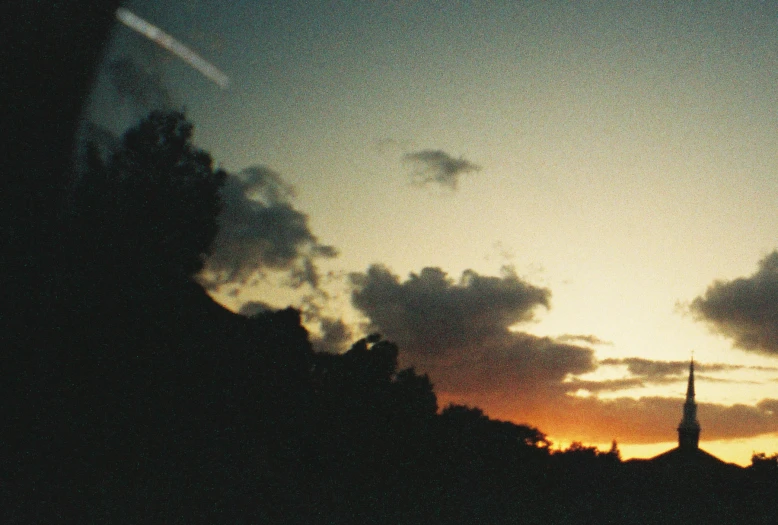 a building tower with a steeple and a cross in the sky