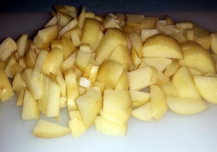 chopped up pieces of potatoes are on a white plate