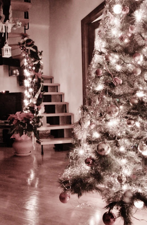a white christmas tree in an apartment with staircase and christmas lights on it